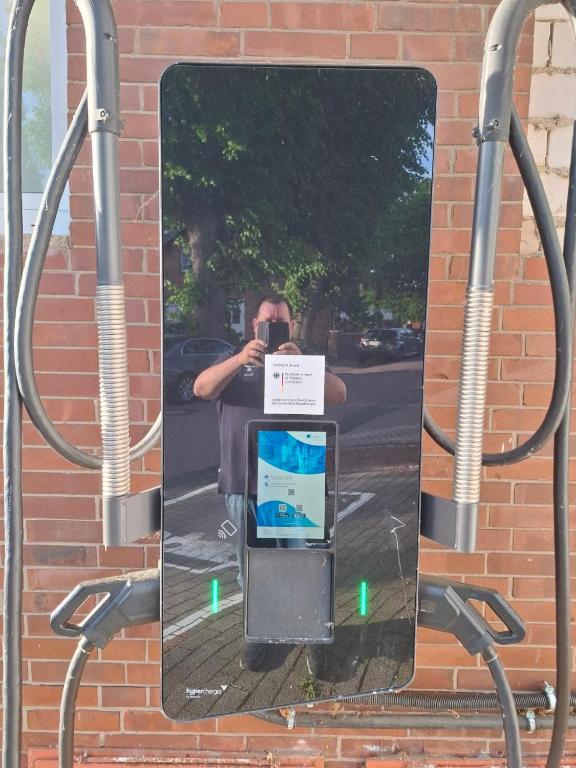 a mirror on a bus stop with a man taking a picture at Hotel zur Post in Steimbke
