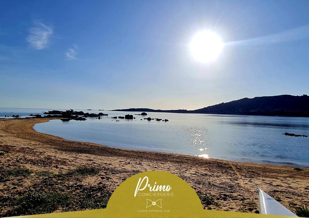 a beach with the sun rising over the water at La Bergerie de Pauline - Bord de mer, vue unique in Pianottoli-Caldarello
