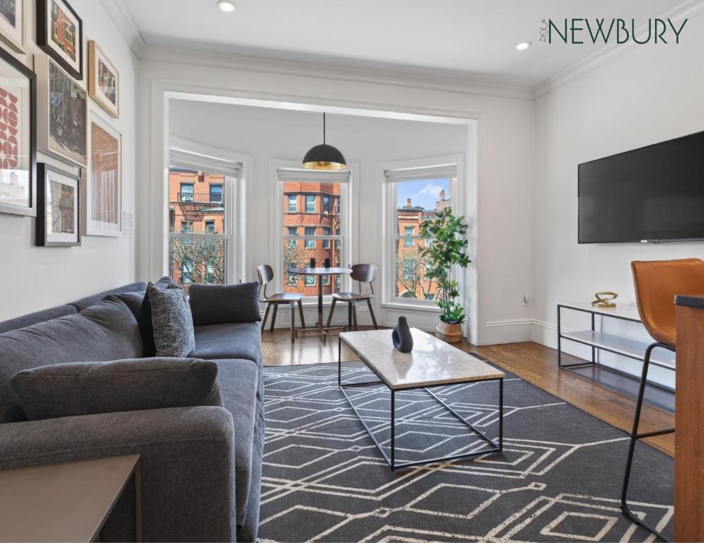 a living room with a couch and a tv at 304 Newbury Street by Thatch in Boston