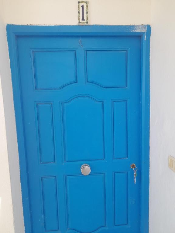 a blue door in a white wall at Taguermess Tag 1 in Midoun