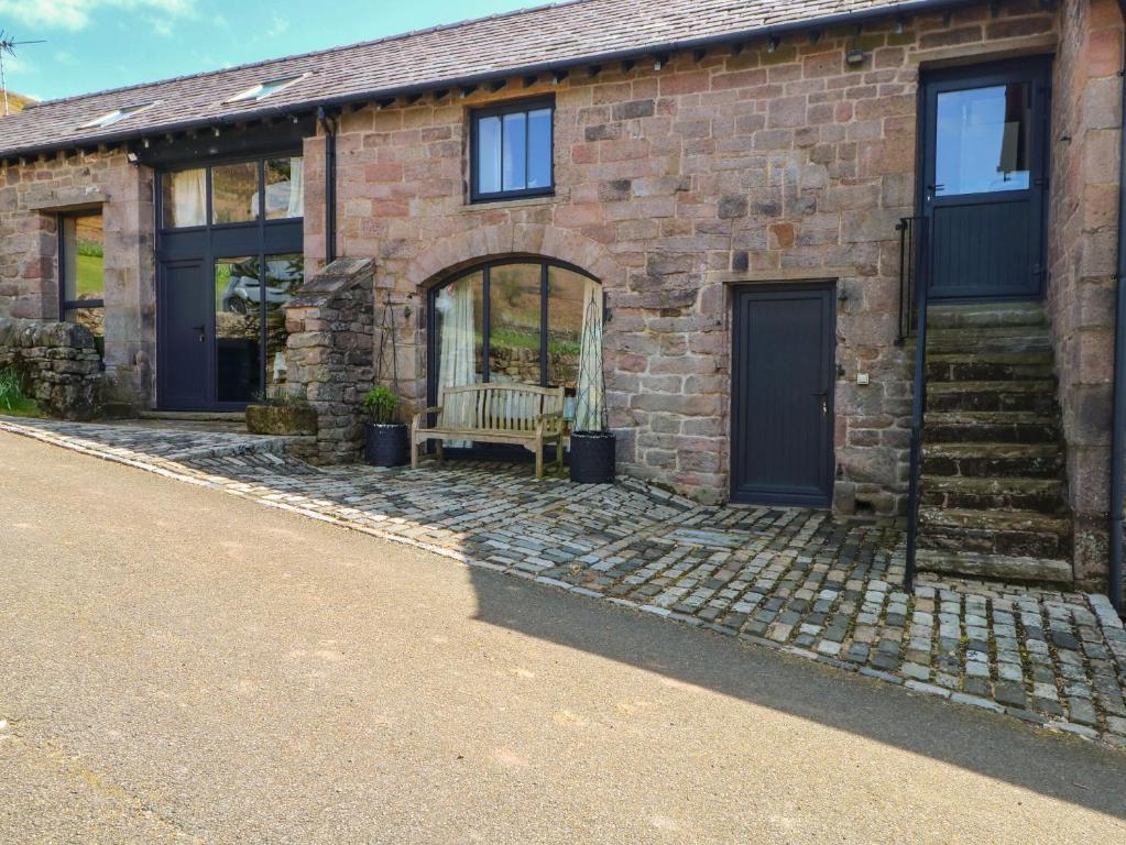 a brick house with a bench in front of it at Pearls Farm Two in Macclesfield