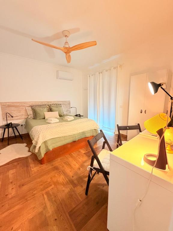 a bedroom with a bed and a ceiling fan at A Janela do Cantinho in Reguengos de Monsaraz