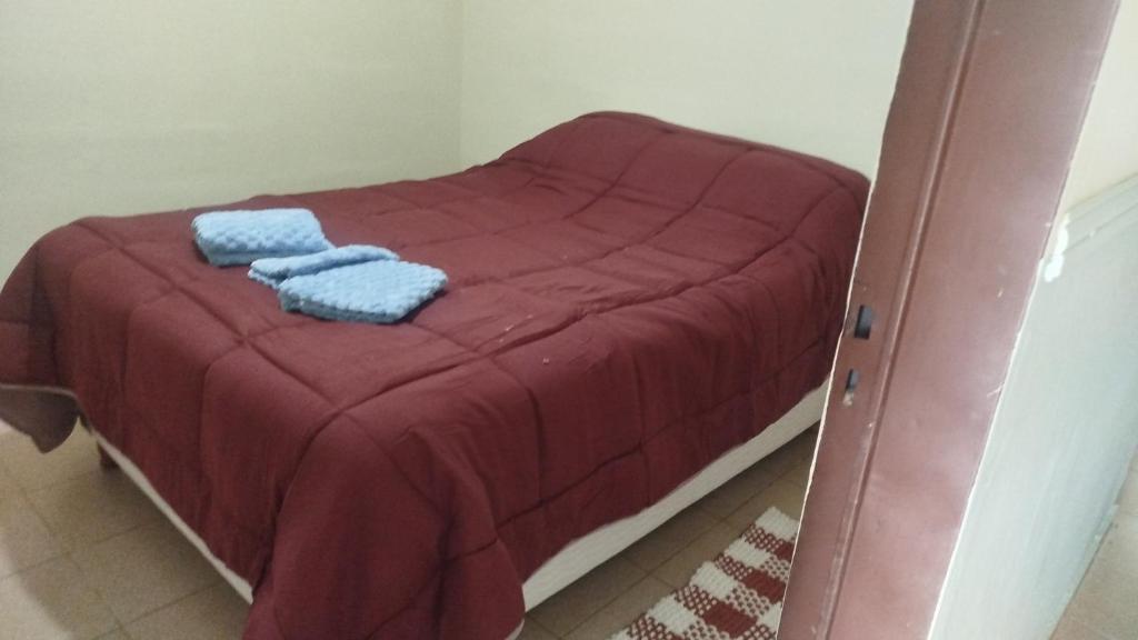 a small bed with two blue towels on it at ruta 8 suites in Santa Catalina