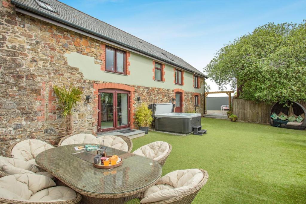 a patio with a table and chairs in a yard at 6 Bed in Holsworthy oc-s41430 in Merryfield