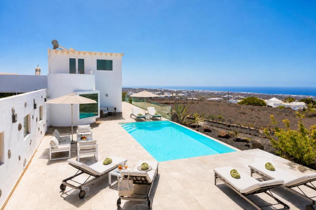 a villa with a swimming pool and the ocean at The View in Tías