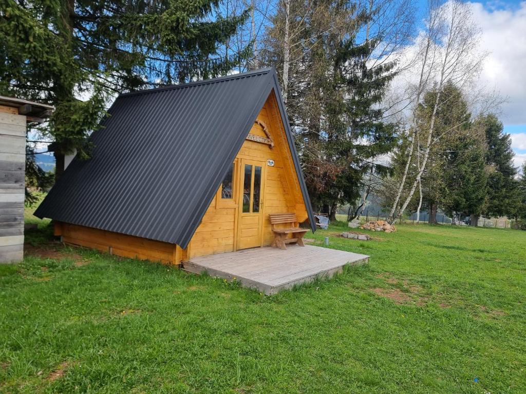 a small wooden cabin in a field of grass at Auto kamp Runolist in Rožaje