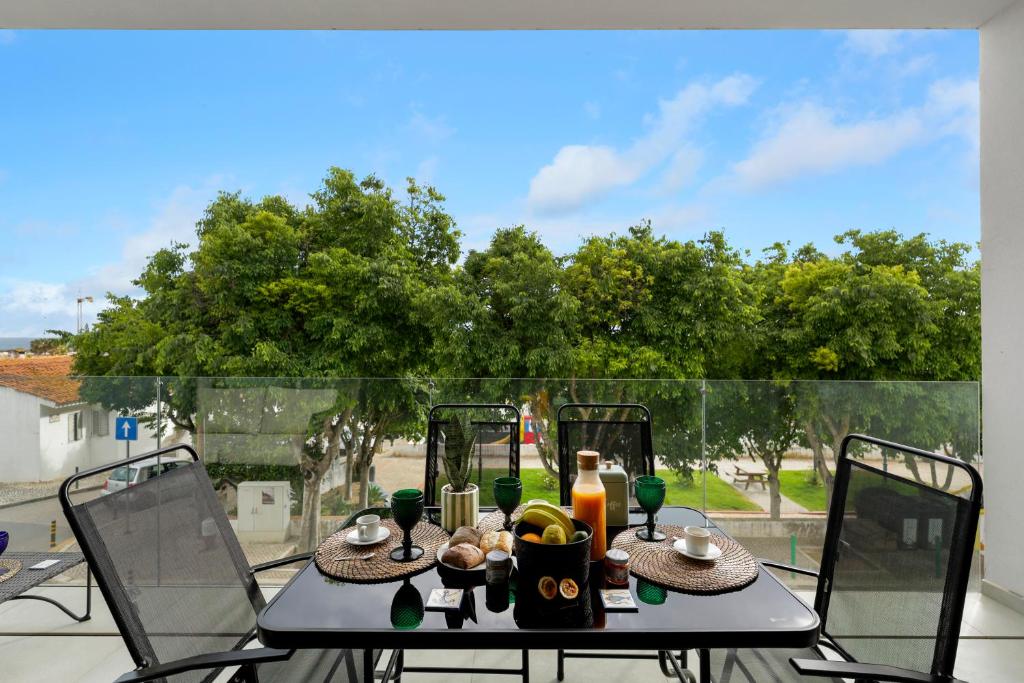 a table with food and drinks on a balcony at JB RiaMar ll by Meditrust in Alvor
