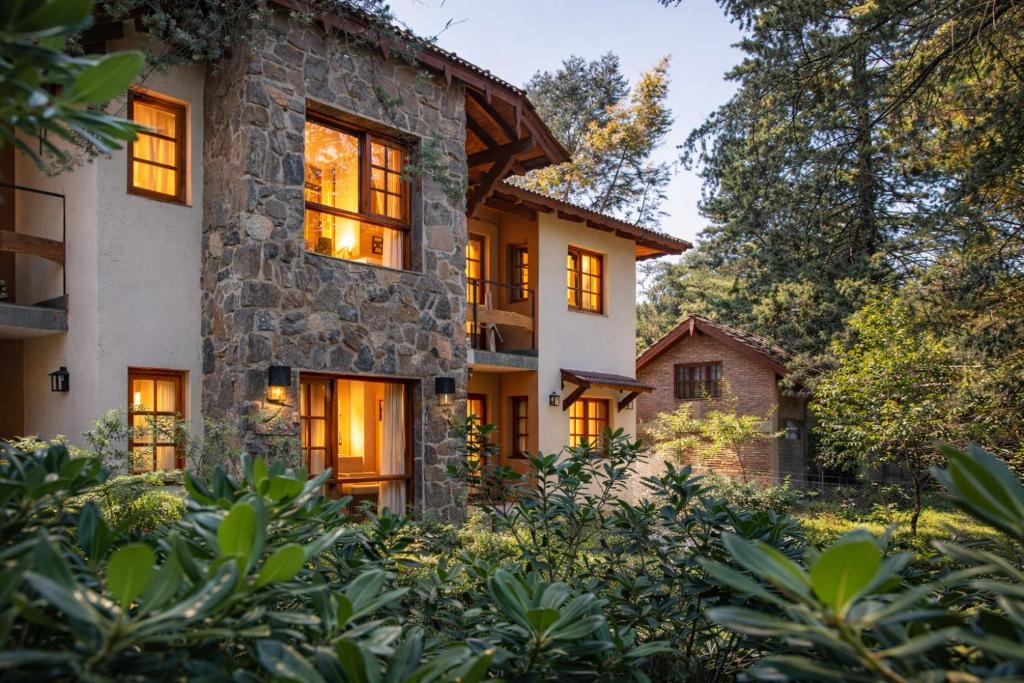 an exterior view of a stone house with trees at Blumenau Apart Hotel in Villa General Belgrano