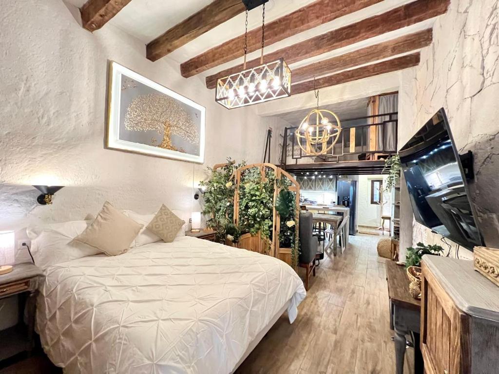 a bedroom with a white bed and a dining room at Loft Iduri en ValQuirico in Santeagueda