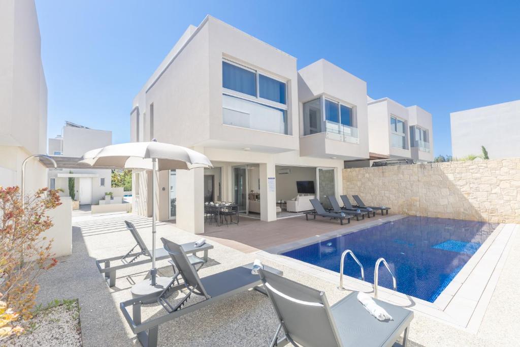 a villa with a swimming pool and a house at Mythical Blue Villas in Protaras