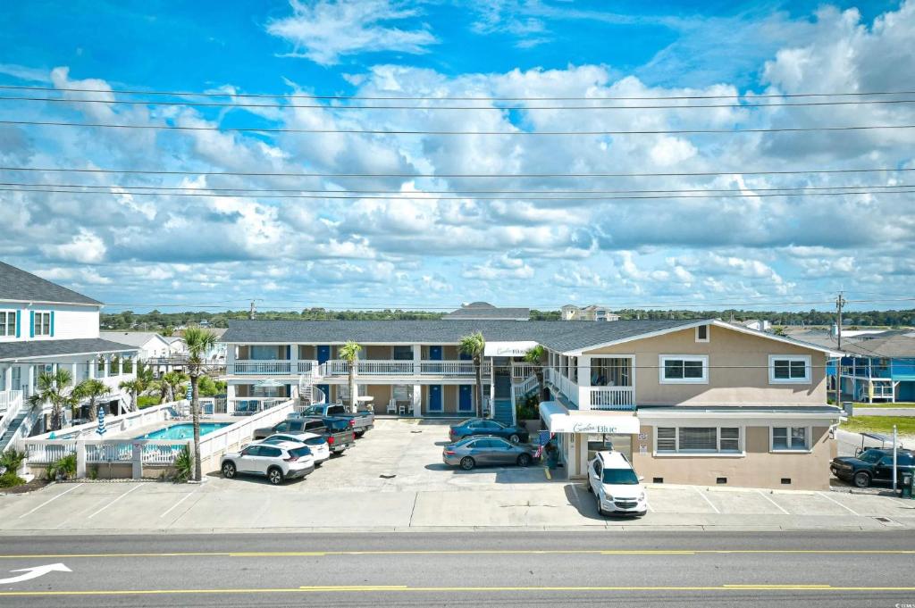 a row of buildings with cars parked in a parking lot at Carolina Blue in North Myrtle Beach
