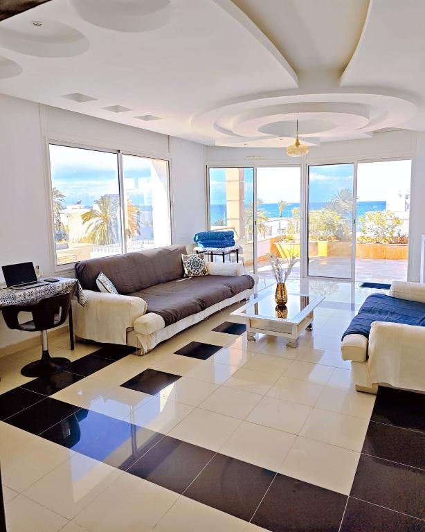 a living room with a couch and a table at Dar Essaada - Exceptionel duplex de 270 M2, plage à 2 min à pieds in Mahdia