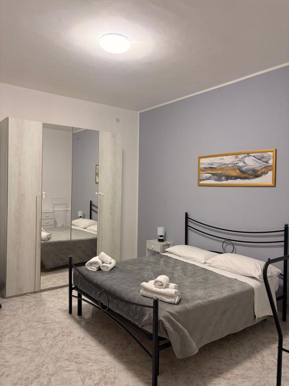 a bedroom with a large bed and a mirror at Casa vacanza da Sandro in Priolo Gargallo