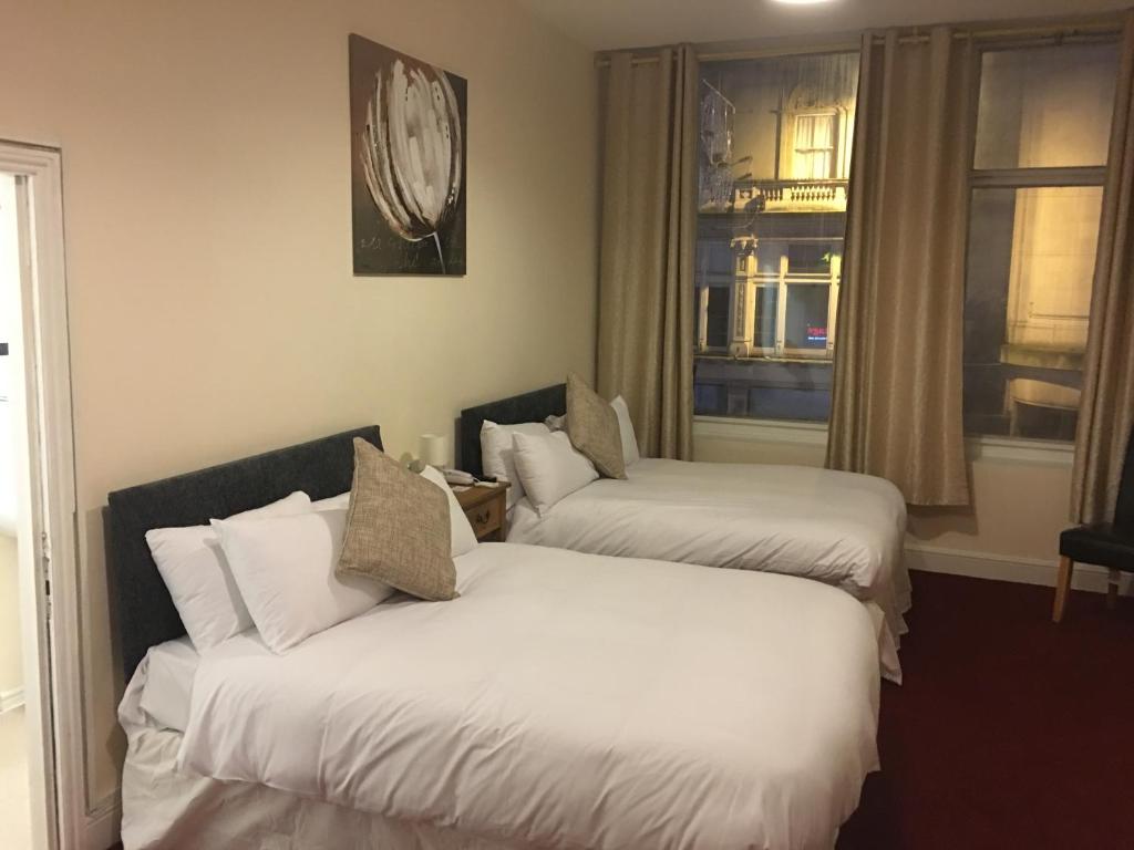 a hotel room with two beds and a window at ML Lodge in Cardiff