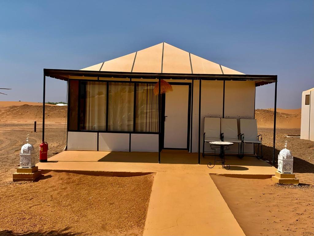 a small building in the middle of the desert at ChariF Luxury Camp in Rissani