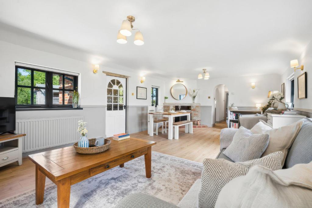 a living room with a couch and a table at Five Acres Cottage in Rickmansworth