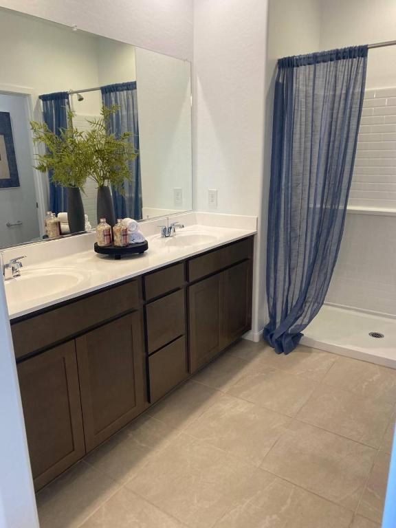 a bathroom with a sink and a mirror and a tub at Clark's Luxury Apartment in Phoenix