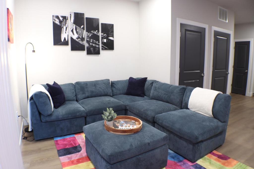 a living room with a blue couch and a table at The Drop Inn NWA Basecamp in Rogers