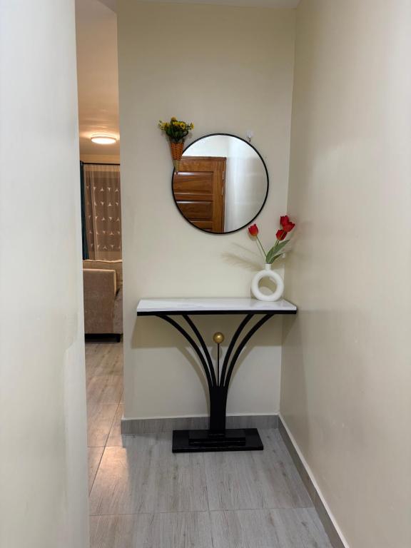 a mirror and a table with a vase on it at Savana Abode-Nakuru CBD in Nakuru