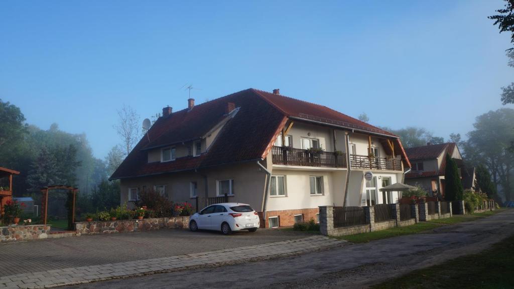 a white car parked in front of a house at Seeblick in Olecko