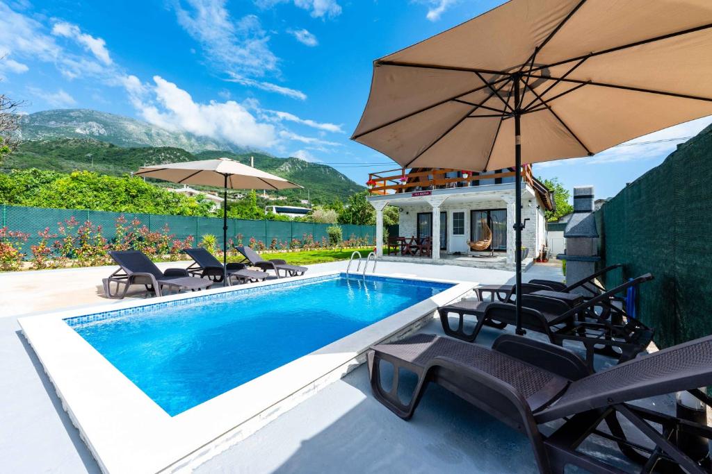 a swimming pool with chairs and an umbrella at Villa Ksenija with Private Pool- Peace & Privacy in Bar