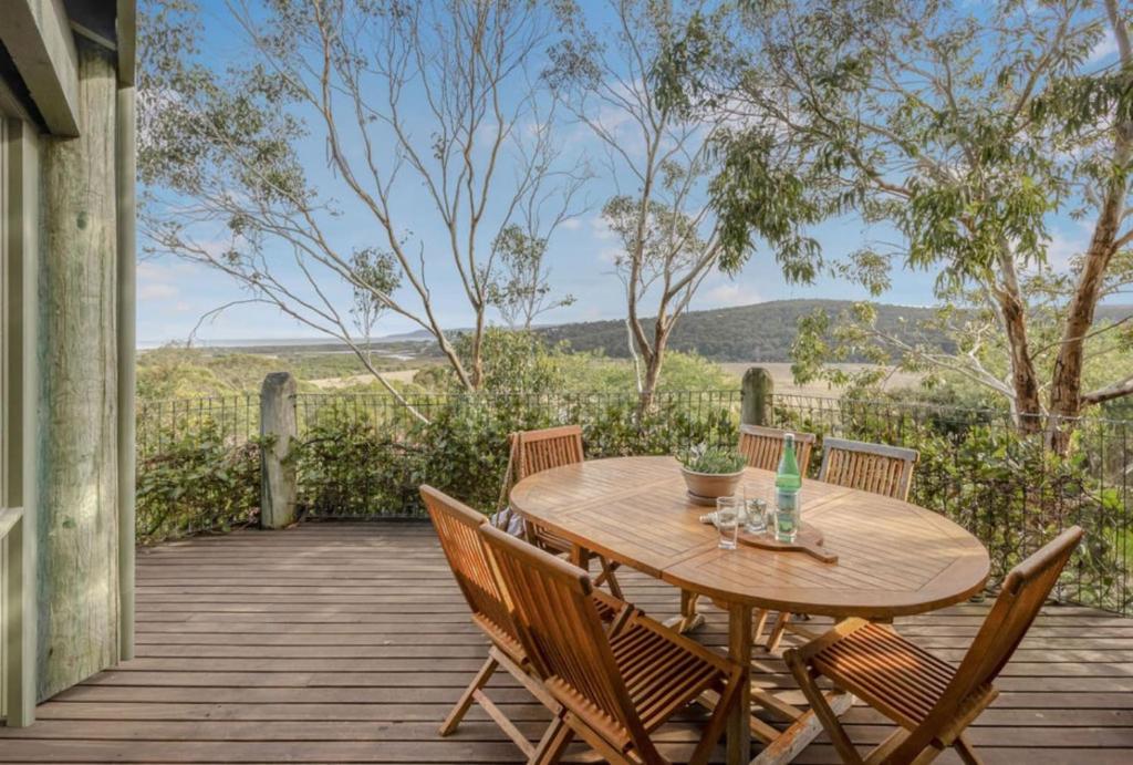 a wooden table and chairs on a wooden deck at The Ridge House Panoramic views in Aireys Inlet
