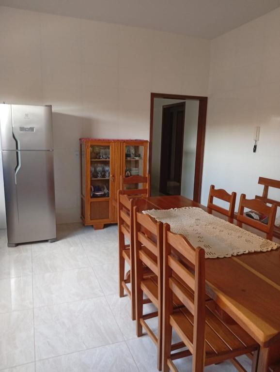 a kitchen with a dining table and a refrigerator at Casa da Helenice in São Roque de Minas