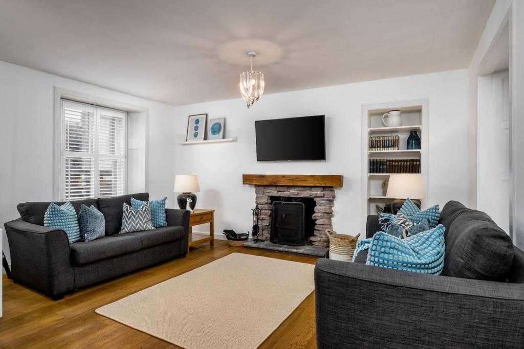 a living room with two couches and a fireplace at Pear Tree Cottage, Dunblane in Dunblane