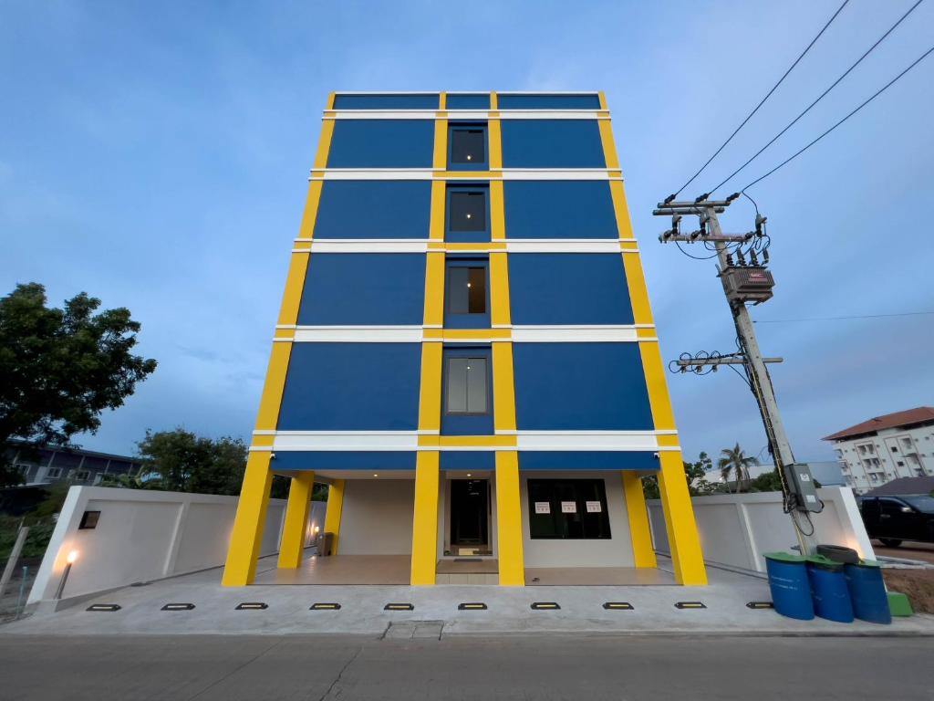 a tall building with yellow and blue paint on it at Toyatsu Residence in Pathum Thani