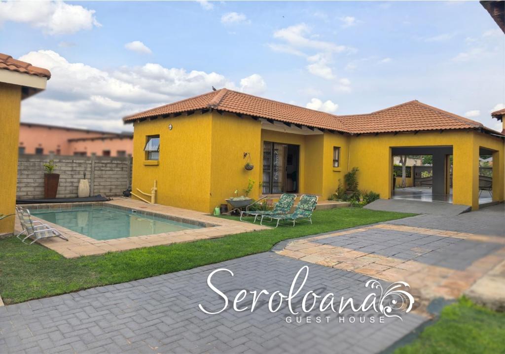 a yellow house with a swimming pool in the yard at Seroloana Guest House in Rustenburg