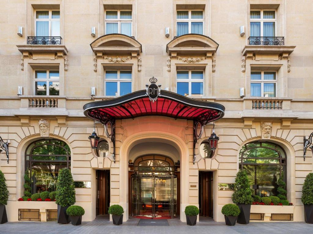 a facade of a building with a red awning at Hôtel Le Royal Monceau Raffles Paris in Paris