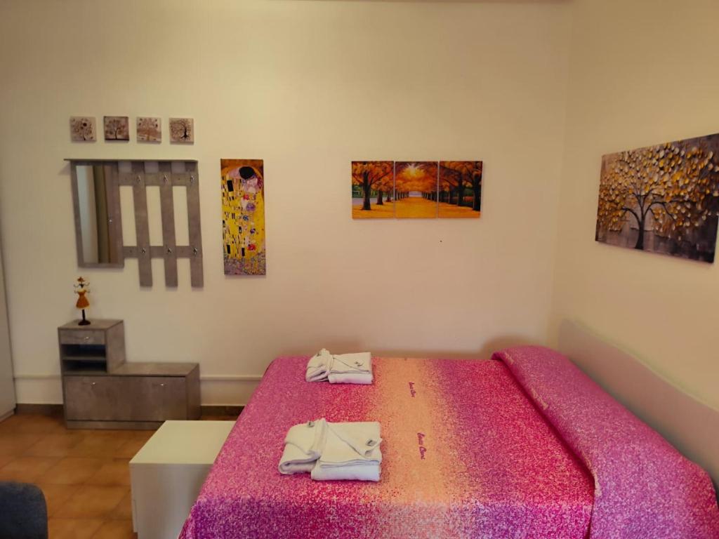 a bedroom with a bed with a pink blanket at brezza marina in Siderno Marina