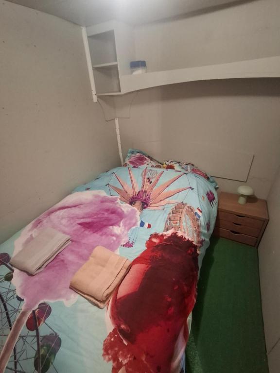 a bedroom with a bed with a painting on it at Chambre d'hôte Mles bêtes in Avensan
