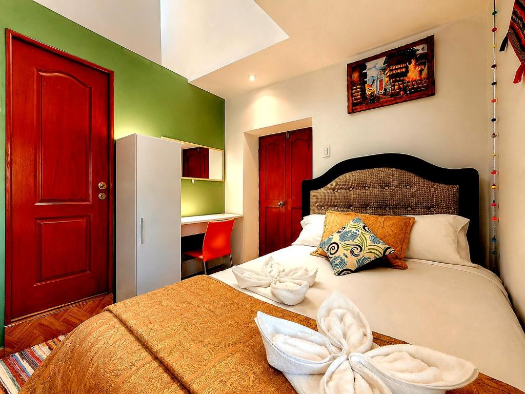 a bedroom with a bed with a red door at wayra house san blas in Cusco