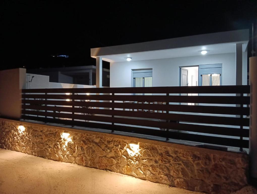 a house with lights on a fence at night at Stegna Holiday 2 in Archangelos