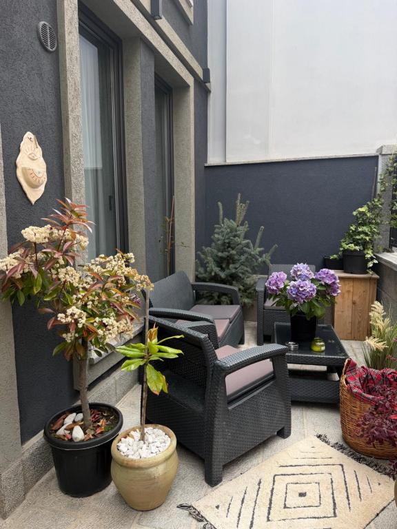 a patio with chairs and potted plants on a building at Liams Cozy Villa in Korçë