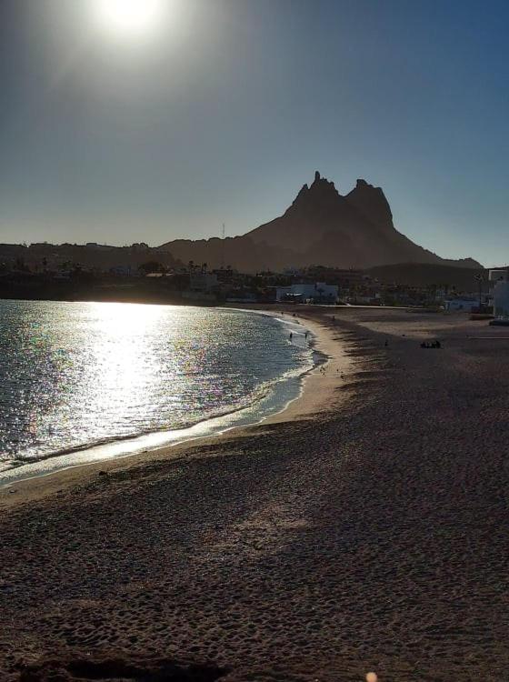 a beach with the sun shining on the water at Ocean Light at Villa Hermosa in San Carlos