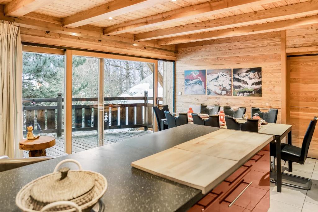 a dining room with a table and chairs at CHALET EVEREST Les CHALETS D'HINOUKA SERRE CHEVALIER-CHANTEMERLE 200 m des pistes in Saint-Chaffrey