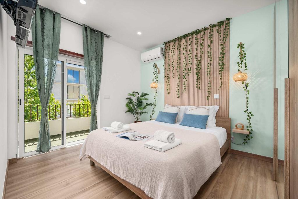 a bedroom with a large bed with towels on it at Stylish & Sleek Flat near the Beach by HostWise in Armação de Pêra