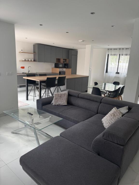 a living room with a couch and a dining room at Maison proximité de la plage in Plouzané