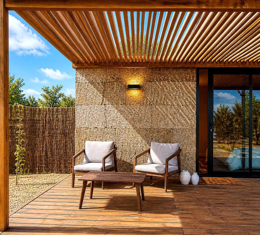 two chairs and a table on a wooden deck at Luz Retreat in Luz de Tavira