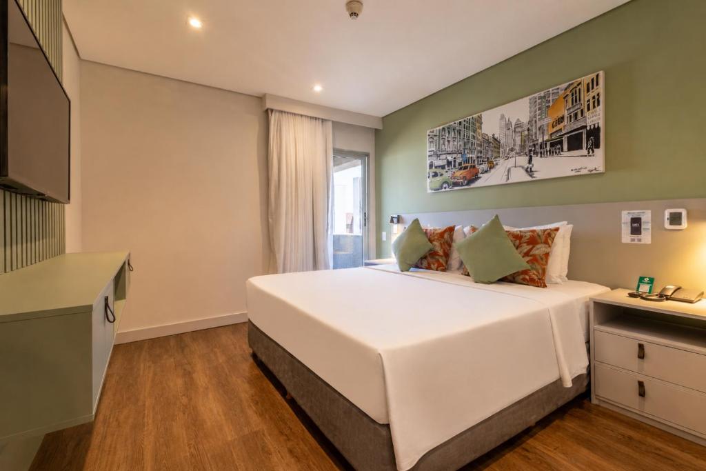 a bedroom with a large white bed and a window at Hotel Transamerica Berrini in São Paulo