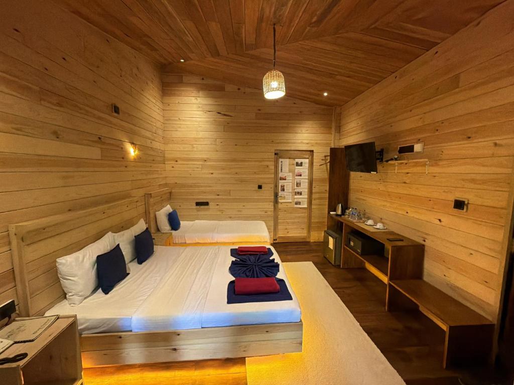 a bedroom with a bed in a wooden room at Wood Chalets Ella in Ella