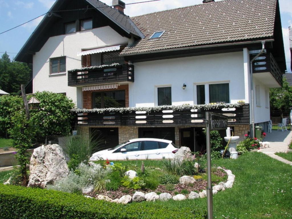 un coche blanco estacionado frente a una casa en Apartment Marinka, en Bled