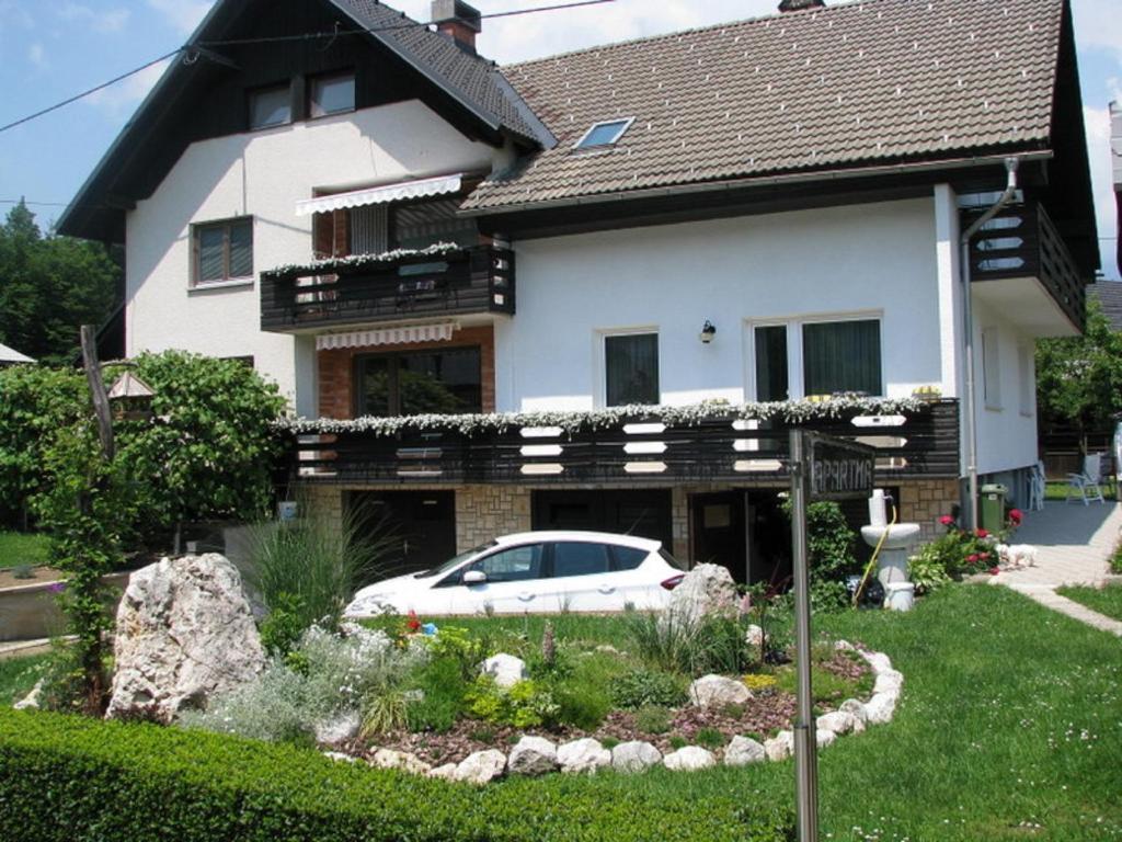 a white car parked in front of a house at Apartment Marinka in Bled