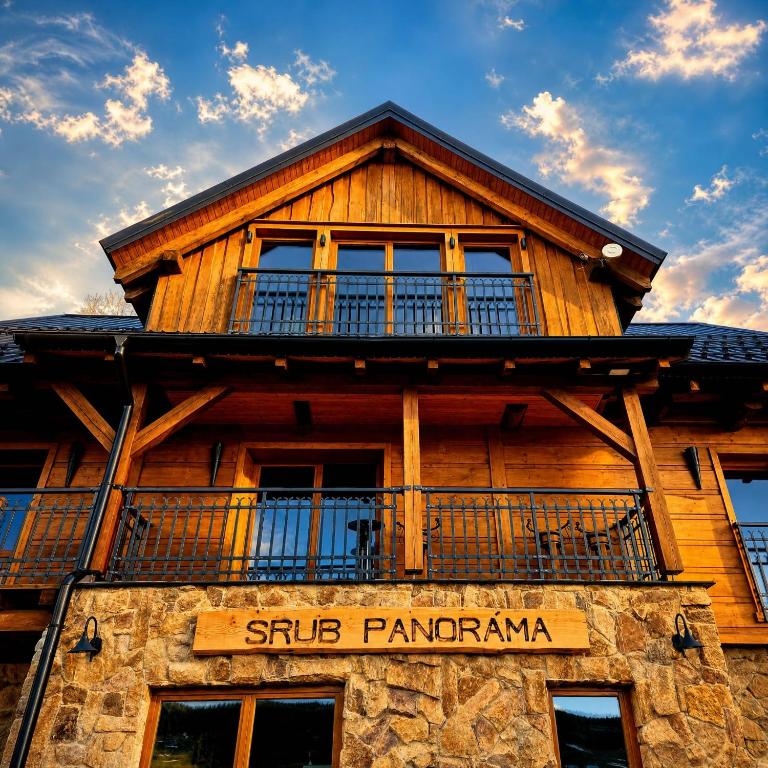 a wooden building with a balcony on top of it at Panorama Lodge in Pec pod Sněžkou