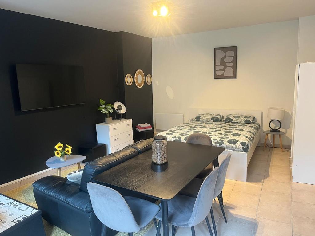 a bedroom with a couch and a table and a bed at Cocon de Tonnerre in Tonnerre