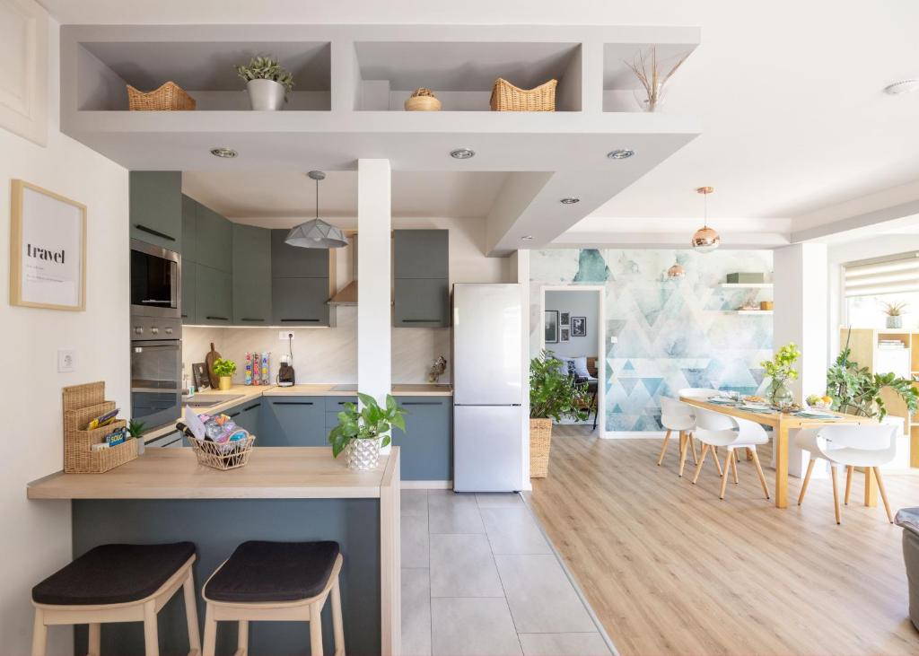 a kitchen with blue cabinets and a table with chairs at Riverside Apartman**** Miskolc in Miskolc