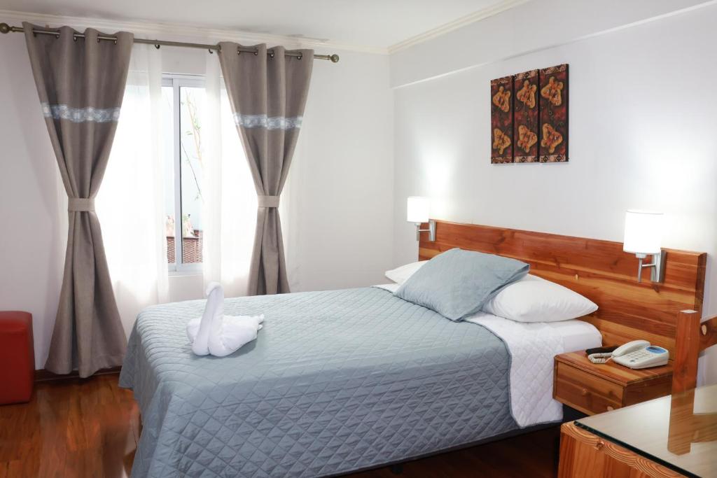 a bedroom with a bed and a window at Hotel Paola Antofagasta in Antofagasta