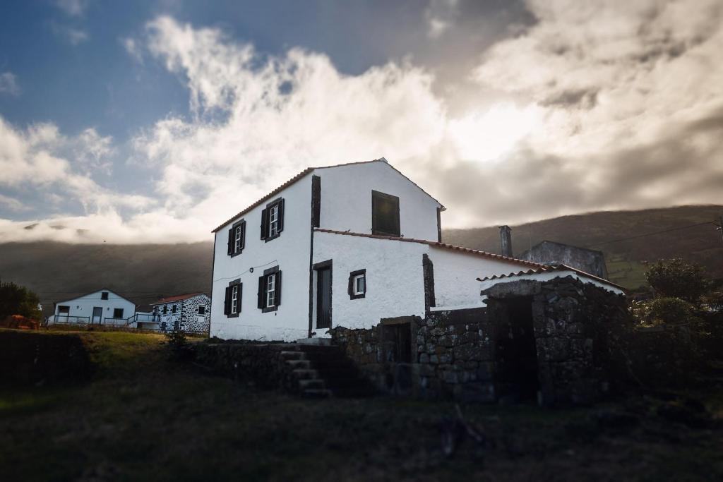 an old white house sitting on top of a hill at Liiiving in Azores - Ocean View House in Canto da Areia